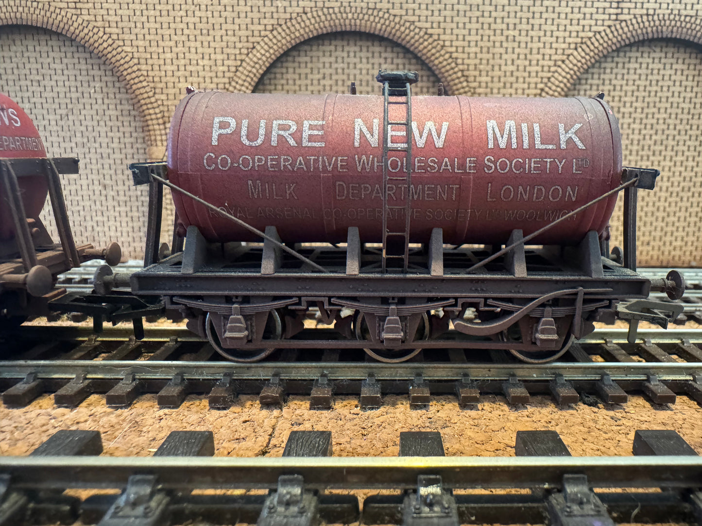 Dapol 4F-031-037 (OO) Co-operative Wholesale Society, weathered ‘Pure New Milk’ Glass Lined Six Wheel Wagon Twin Set (Royal Arsenal Co-op) 